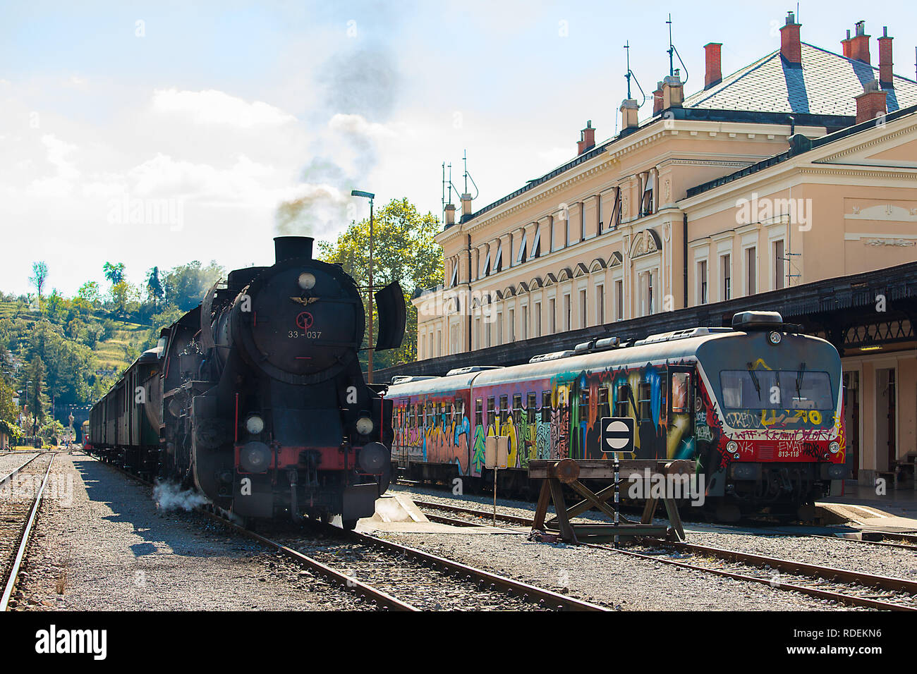 Il vecchio treno a vapore - locomotiva alla stazione ferroviaria di Nova Gorica e nuovo treno elettrico Foto Stock