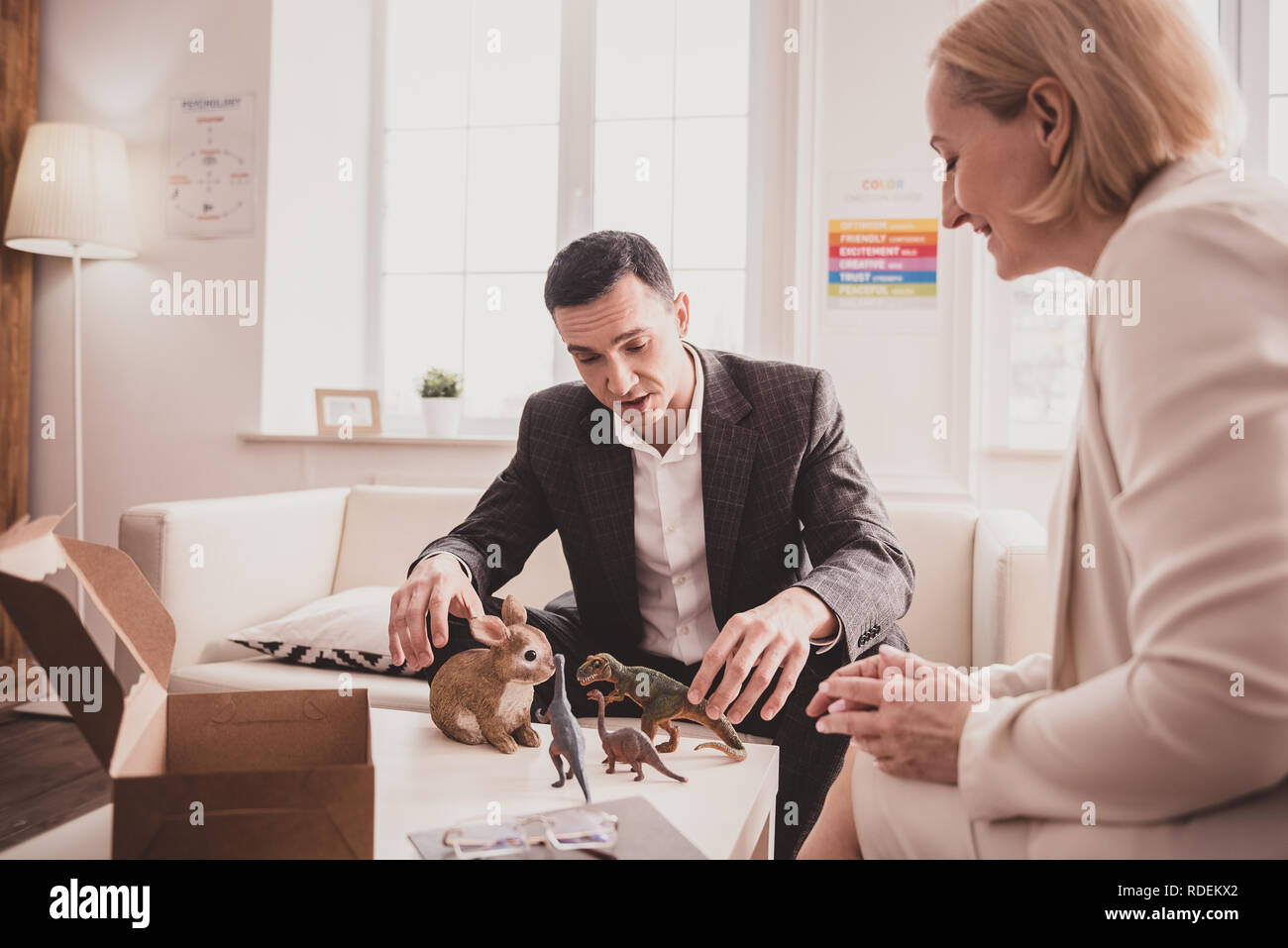 Sconvolto manager giocare con giocattoli durante la terapia Foto Stock