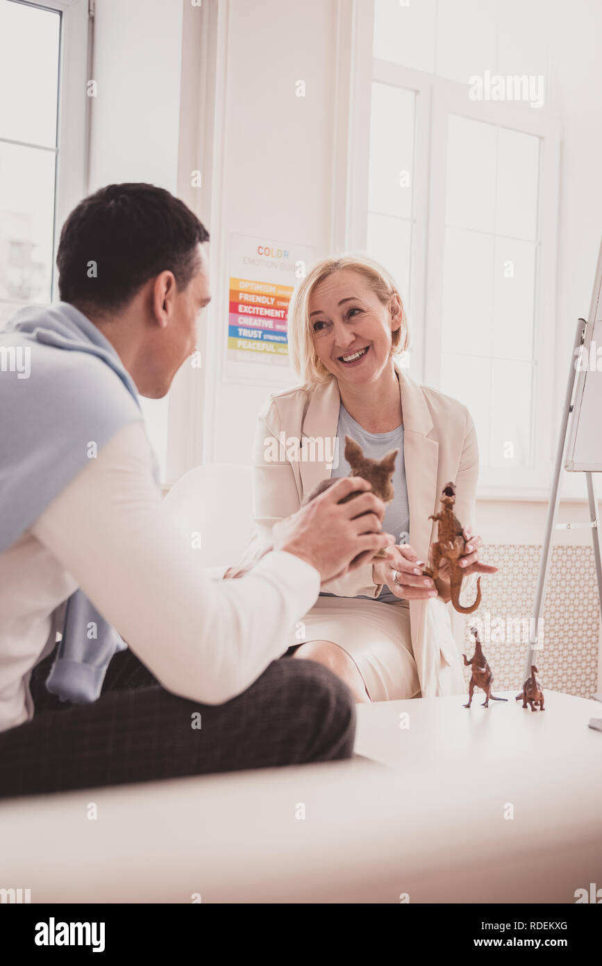 Lieta donna bionda avente friendly parlare con paziente Foto Stock