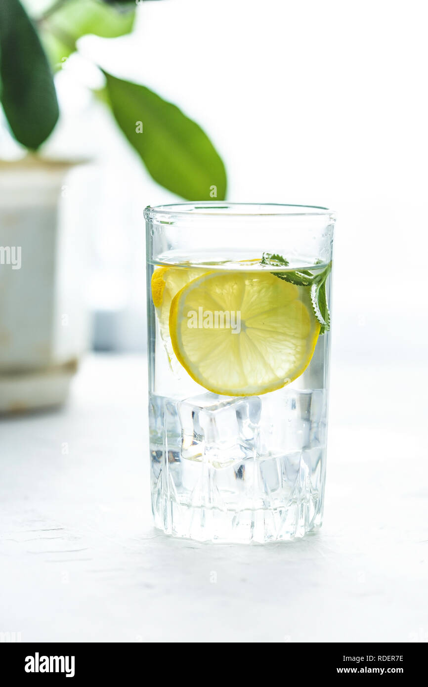 Bicchiere di vetro e una caraffa di acqua, ghiaccio, menta e Bicchiere di vetro e la caraffa con acqua su un tavolo
