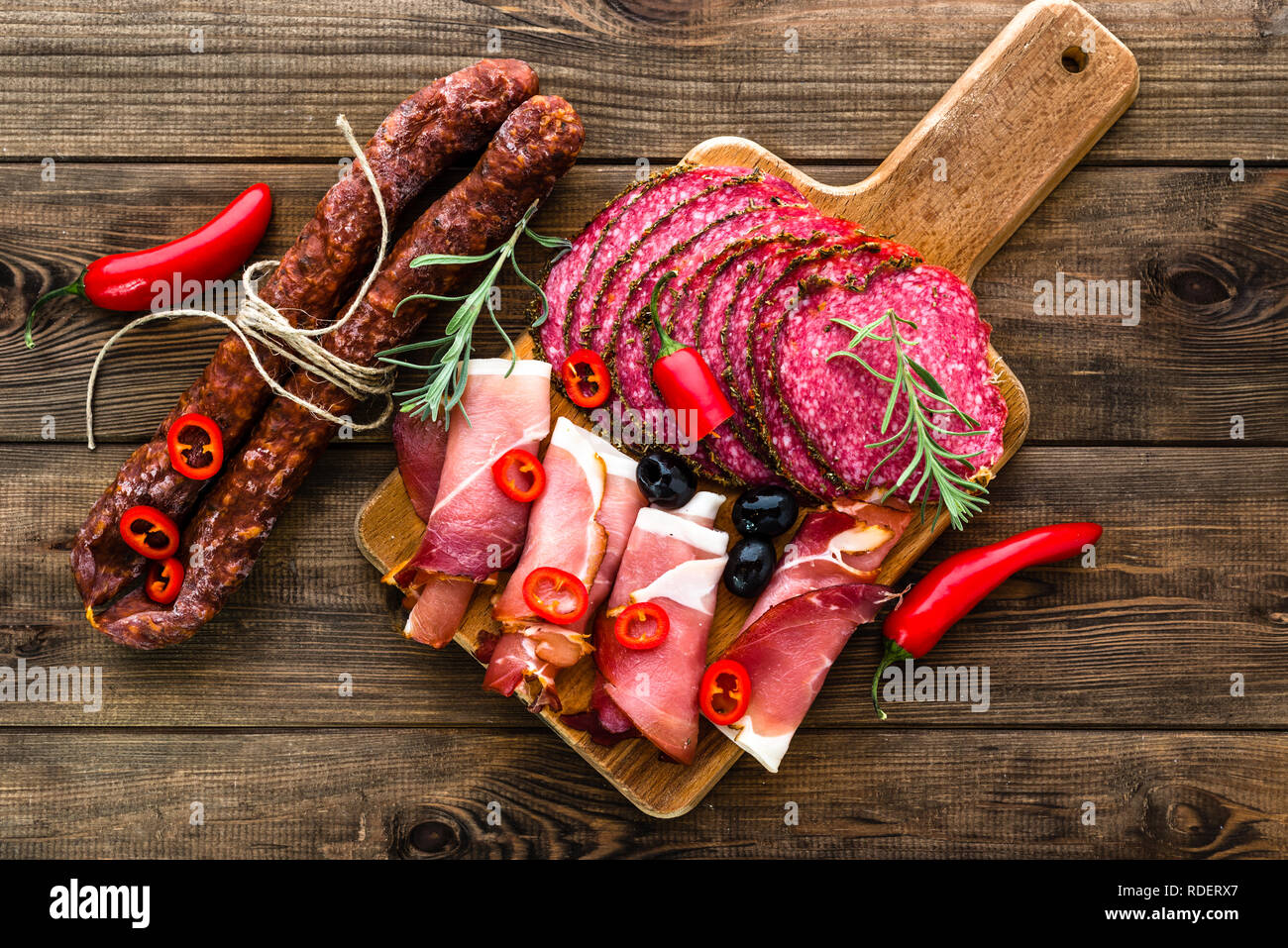 Tapas tradizionali spagnole il cibo da bar sul piatto da portata, selezione di carne fredda, salsiccia, chorizo, fette di salame, prosciutto sul tavolo di legno Foto Stock