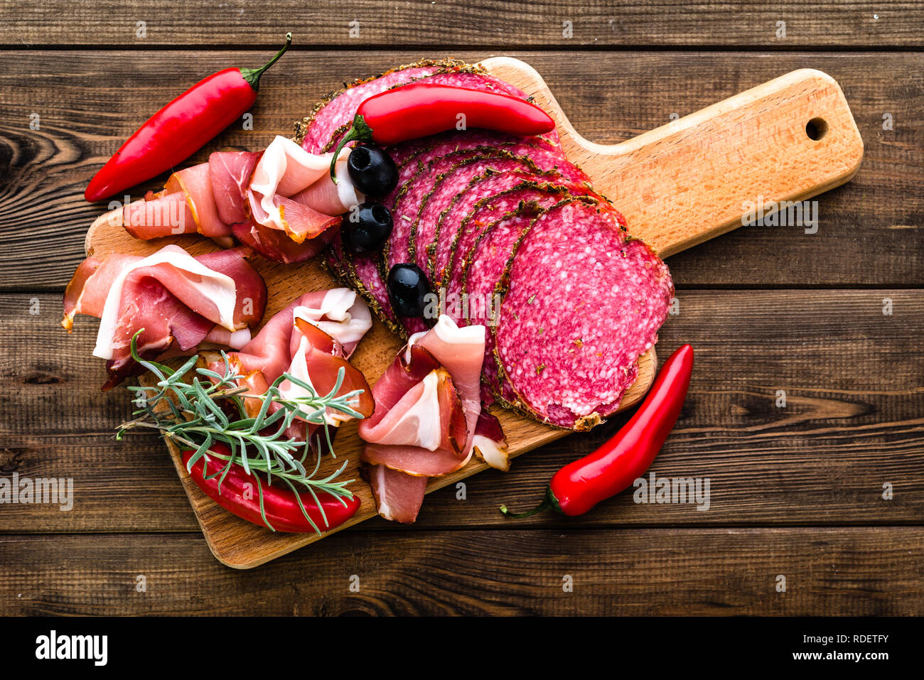 Carne fredda piatto con salame, fette di prosciutto, antipasti italiani sulla tavola di legno Foto Stock