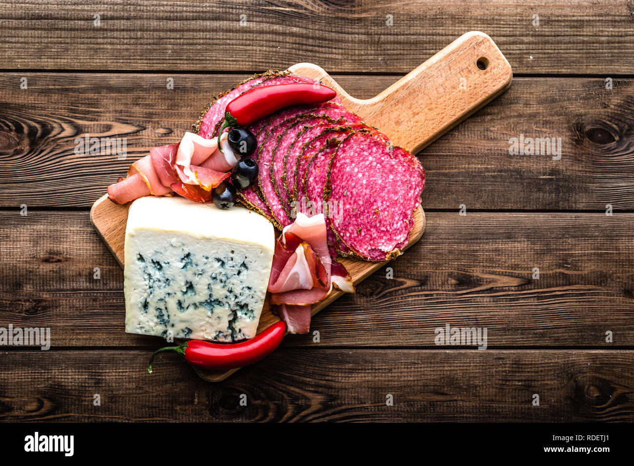 Formaggio blu e carne fredda piatto con salame, fette di prosciutto, antipasti all'italiana su tavola di legno Foto Stock