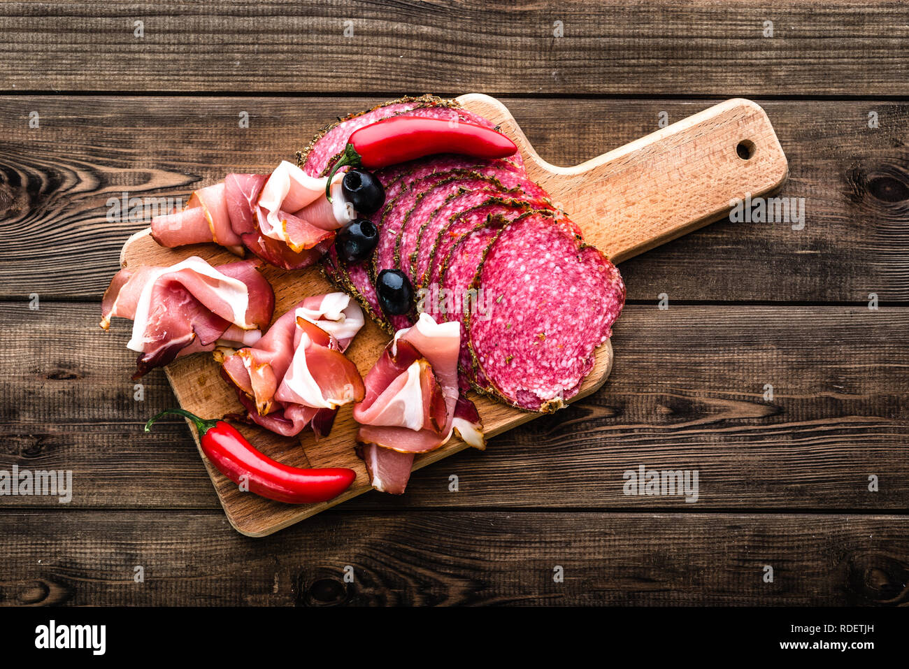 Carne fredda piatto con salame, fette di prosciutto, antipasti italiani sulla tavola di legno Foto Stock
