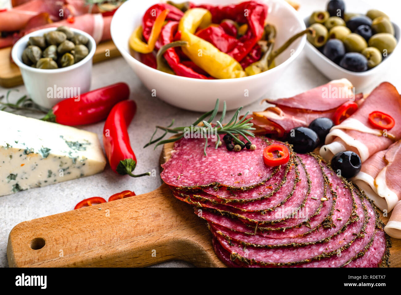 La tabella con i prodotti alimentari provenienti dalla Spagna, fette di salame, prosciutto e altri antipasti piccanti, DIETA MEDITERRANEA Foto Stock