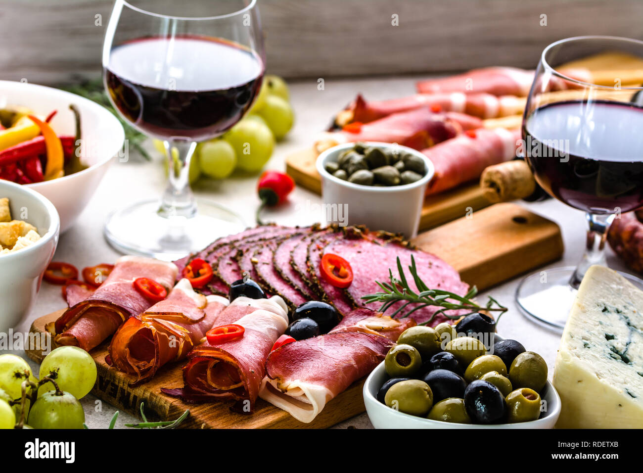 Selezione di cibo, vino snack sul tavolo, antipasti italiani, prosciutto, salame, olive, formaggio e altro aperitivo sul piatto Foto Stock