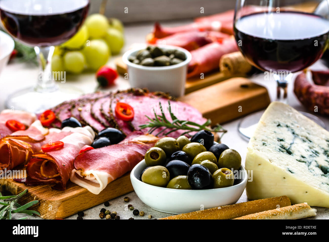 La varietà del cibo su tavola, vino set snack, olive, formaggi e altri aperitivi, antipasti italiani sulla piastra Foto Stock