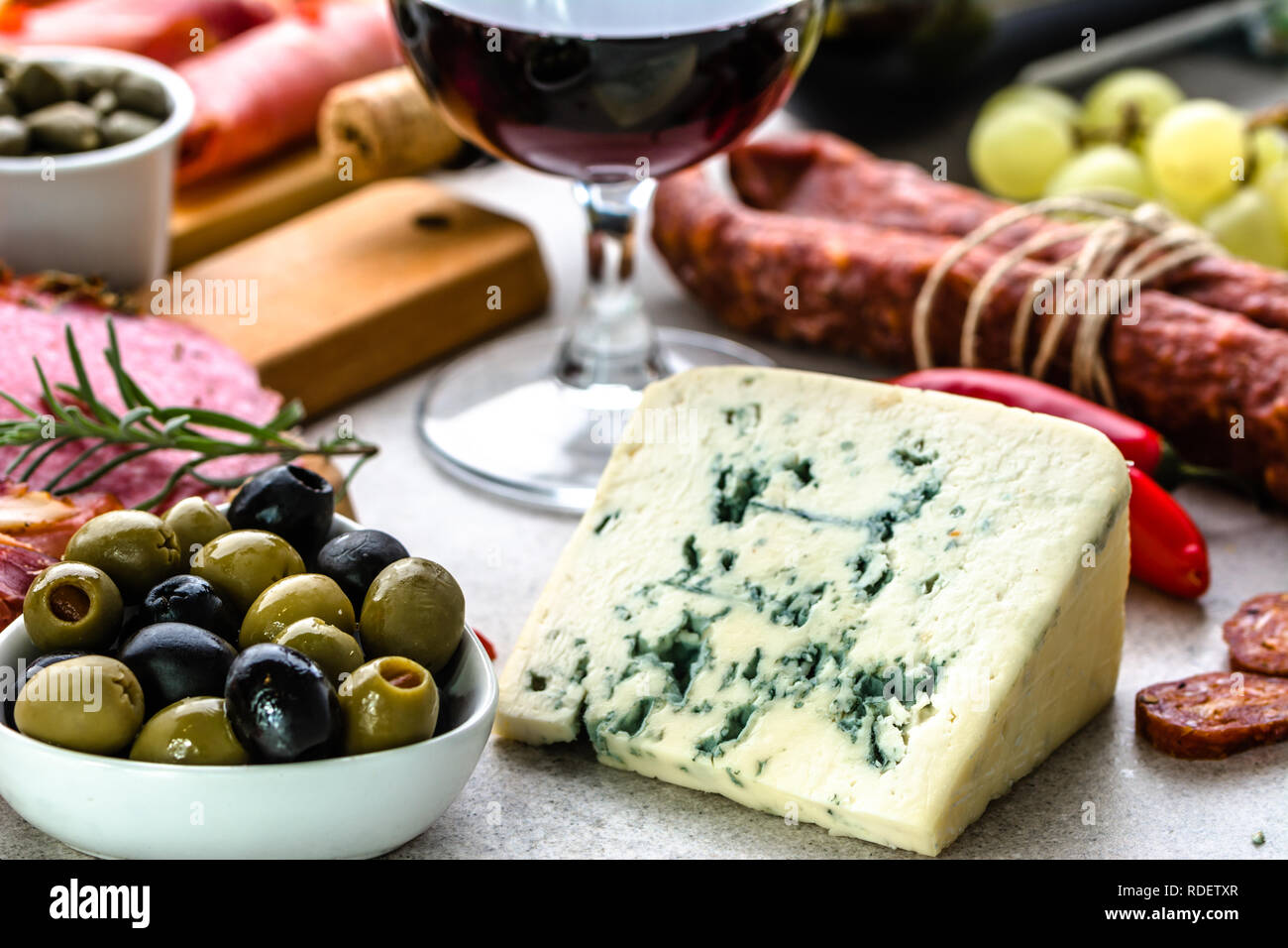 Vino set snack, olive e formaggio blu, antipasti all'italiana, la selezione di cibo sul tavolo Foto Stock