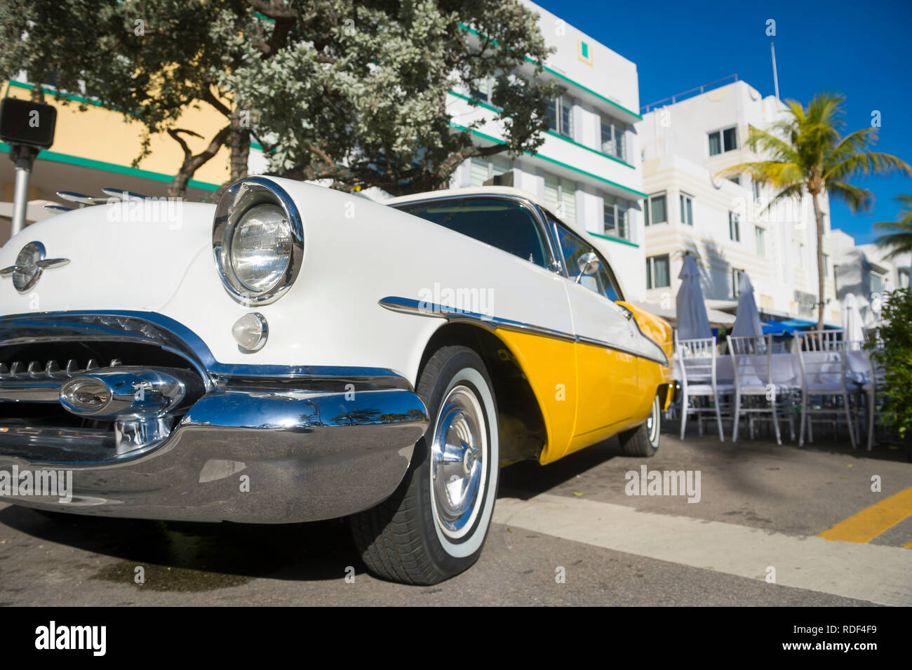 MIAMI - Dicembre 31, 2018: luminoso vista panoramica di classico americano auto a complemento di architettura Art Deco di Ocean Drive sulla spiaggia di South Beach. Foto Stock