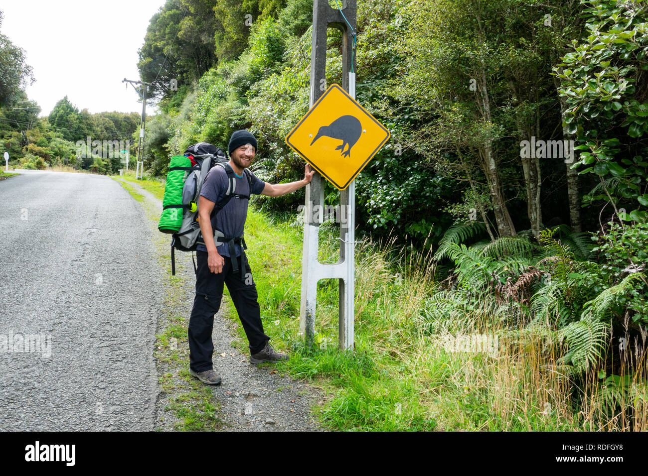 Felice giovani backpacker con uccello Kiwi segno su Stewart Island in Nuova Zelanda, un luogo popolare con i turisti per scorgere uccelli kiwi. Foto Stock