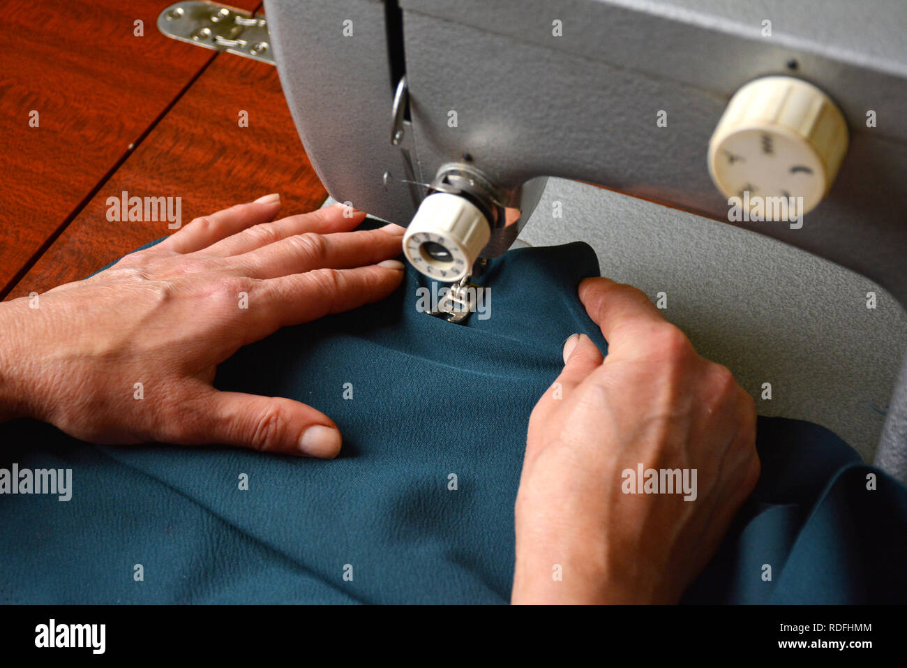 Sarto femmina lavorando sulla macchina da cucire dress industria manifatturiera Foto Stock