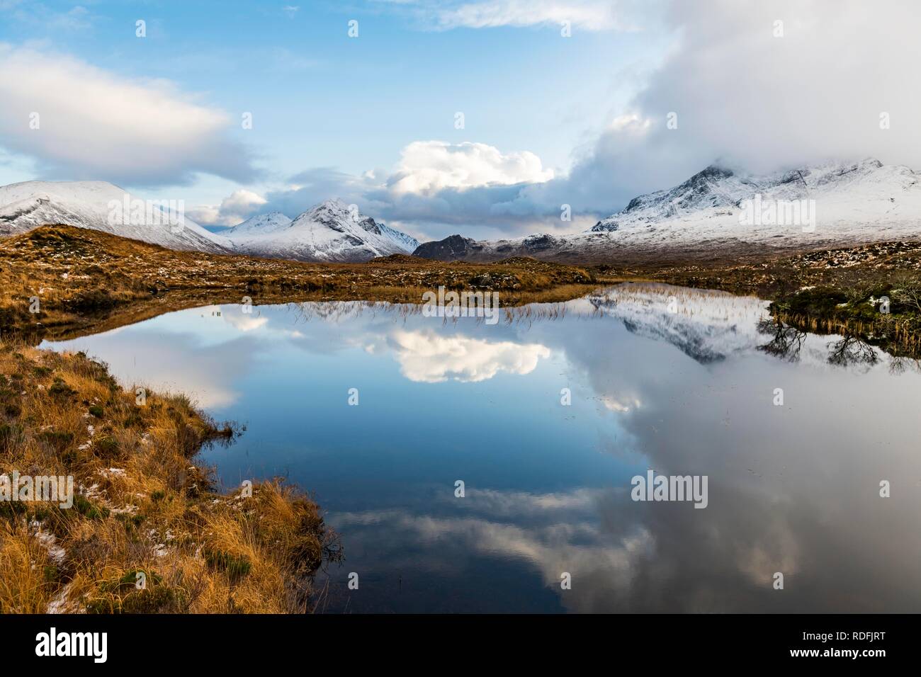 Piccolo lago con la riflessione dell'inverno monti Cullins, Broadford, Isola di Skye, Regno Unito Foto Stock