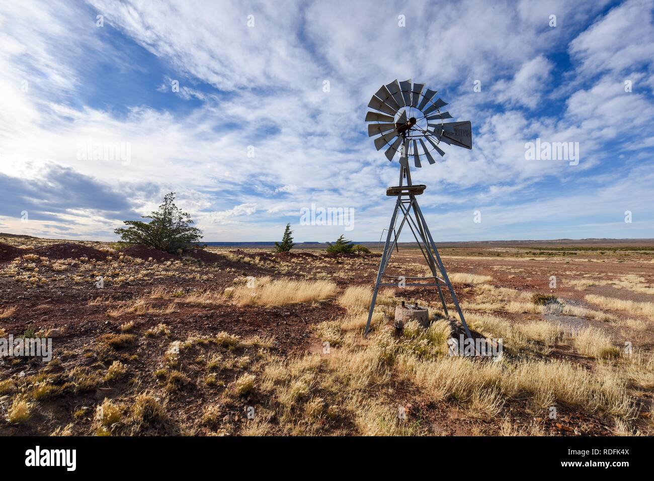 Pampa con il vecchio mulino a vento nella fattoria di Bosques Petrificados de Jaramillo National Park, Patagonia, Argentina Foto Stock