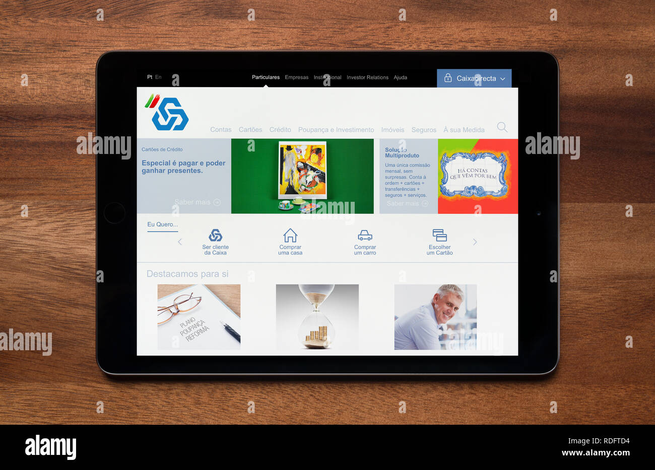 Il sito web di CGD (Caixa Geral de Depósitos) è visto su un tablet iPad, il quale è appoggiato su un tavolo di legno (solo uso editoriale). Foto Stock