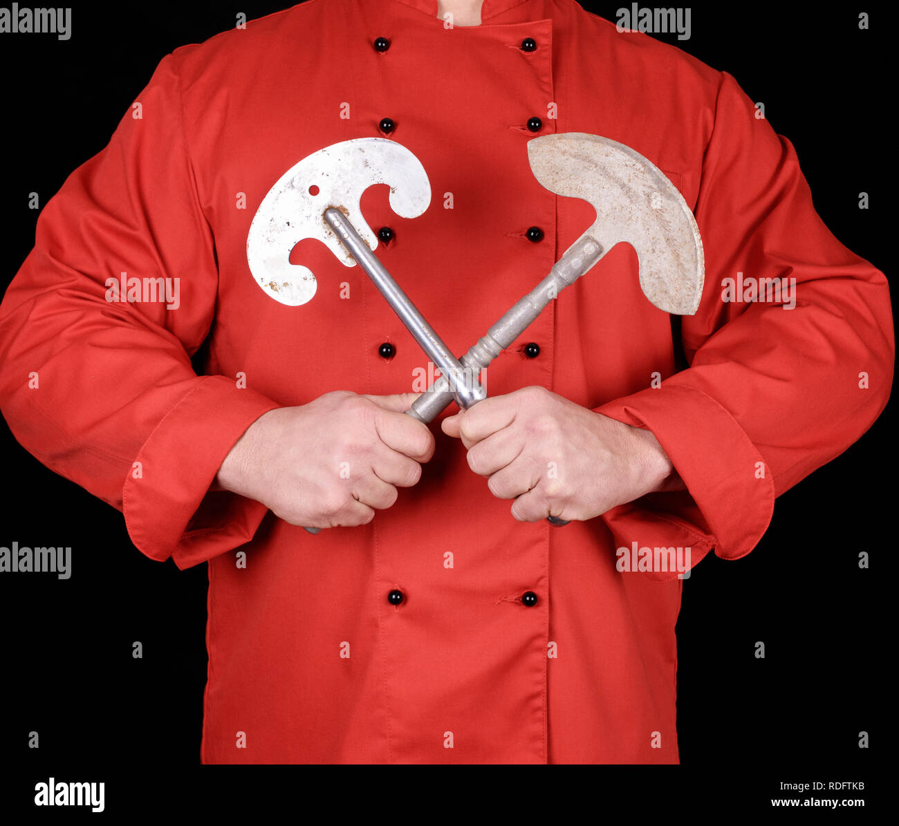 Chef in rosso uniforme tessile azienda vecchi coltelli di metallo per la carne e le verdure Foto Stock