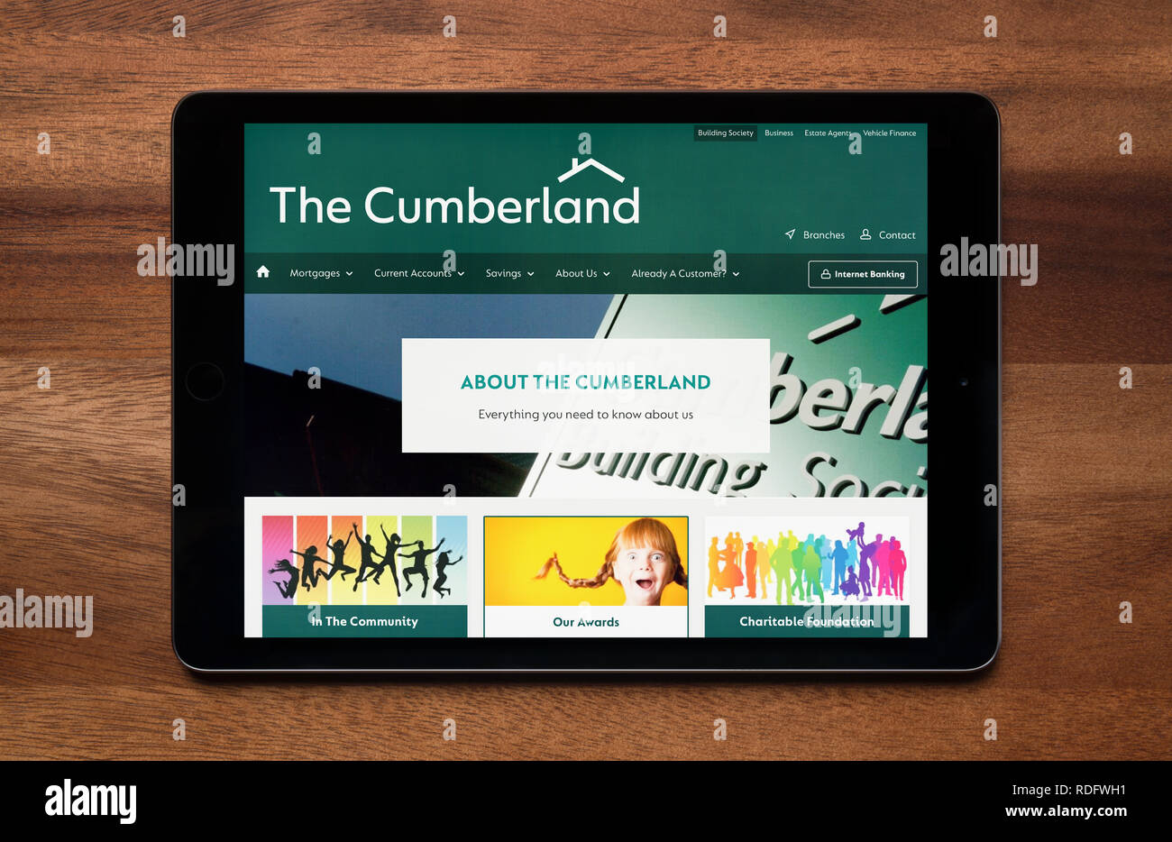 Il sito web di The Cumberland Building Society è visto su un tablet iPad, il quale è appoggiato su un tavolo di legno (solo uso editoriale). Foto Stock