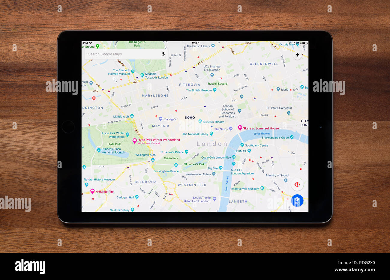 Il sito web di Google Maps è visto su un tablet iPad, il quale è appoggiato su un tavolo di legno (solo uso editoriale). Foto Stock