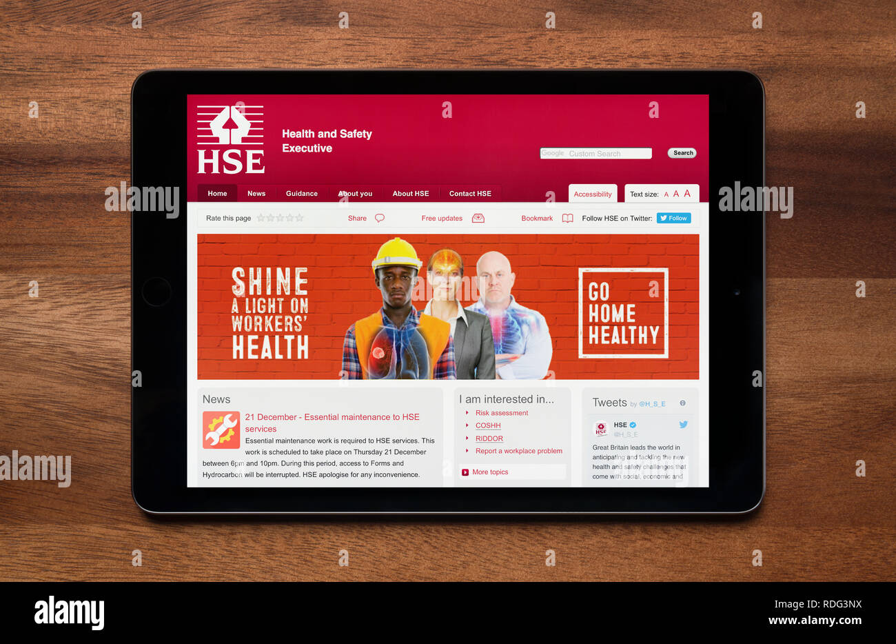 Il sito web di HSE (Comitato esecutivo per la salute e la sicurezza) è visto su un tablet iPad, il quale è appoggiato su un tavolo di legno (solo uso editoriale). Foto Stock