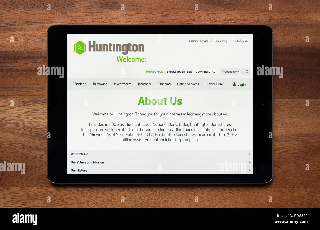 Il sito web di Huntington Bancshares è visto su un tablet iPad, il quale è appoggiato su un tavolo di legno (solo uso editoriale). Foto Stock