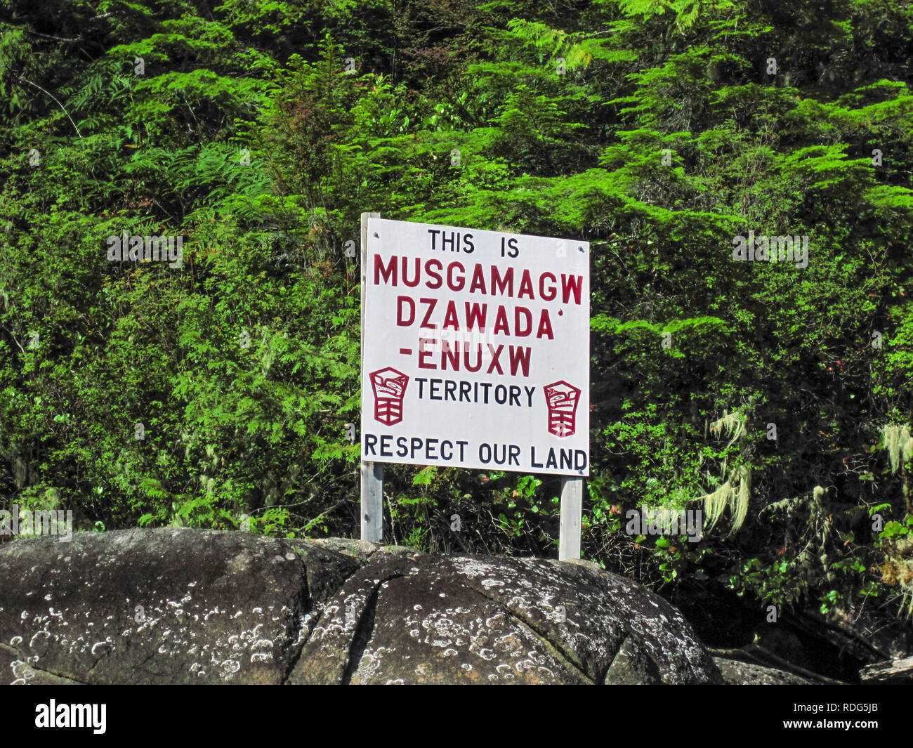 Un segno su una spiaggia rocciosa chiede alla gente di rispettare la terra, parte del territorio della Musgamagw Dzawada'enuxw prima nazione (British Columbia). Foto Stock