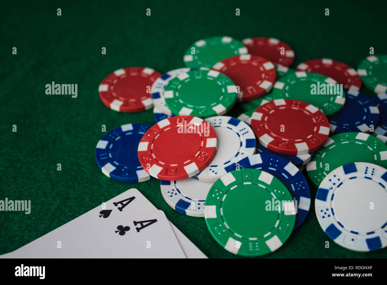 Pila di chips poker e due assi sul tavolo sul green baize. Vista prospettica. Foto Stock