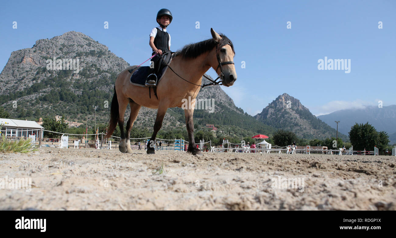 Giovani piloti competere sui loro cavalli e poney su un locale competizione equestre nell'isola spagnola di Ma Foto Stock