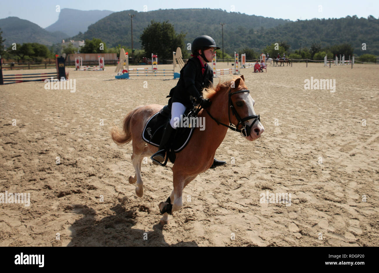 Giovani piloti competere sui loro cavalli e poney su un locale competizione equestre nell'isola spagnola di Ma Foto Stock