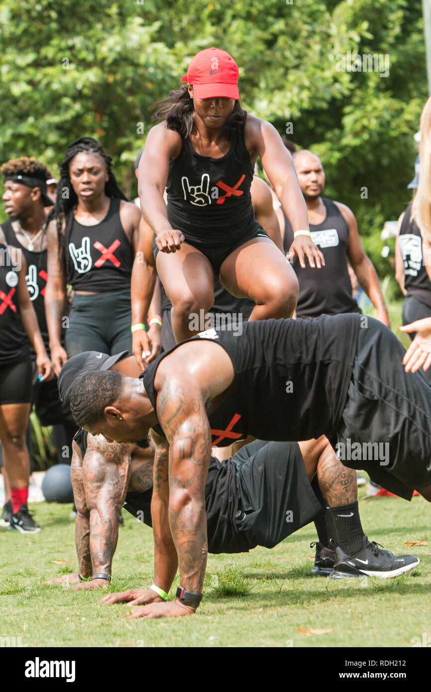 Un atletico donna salta sopra i suoi compagni di squadra maschile come hanno giocato in oltre unders evento al campo di Atlanta giorno sulla luglio 14, 2018 in Atlanta, GA. Foto Stock