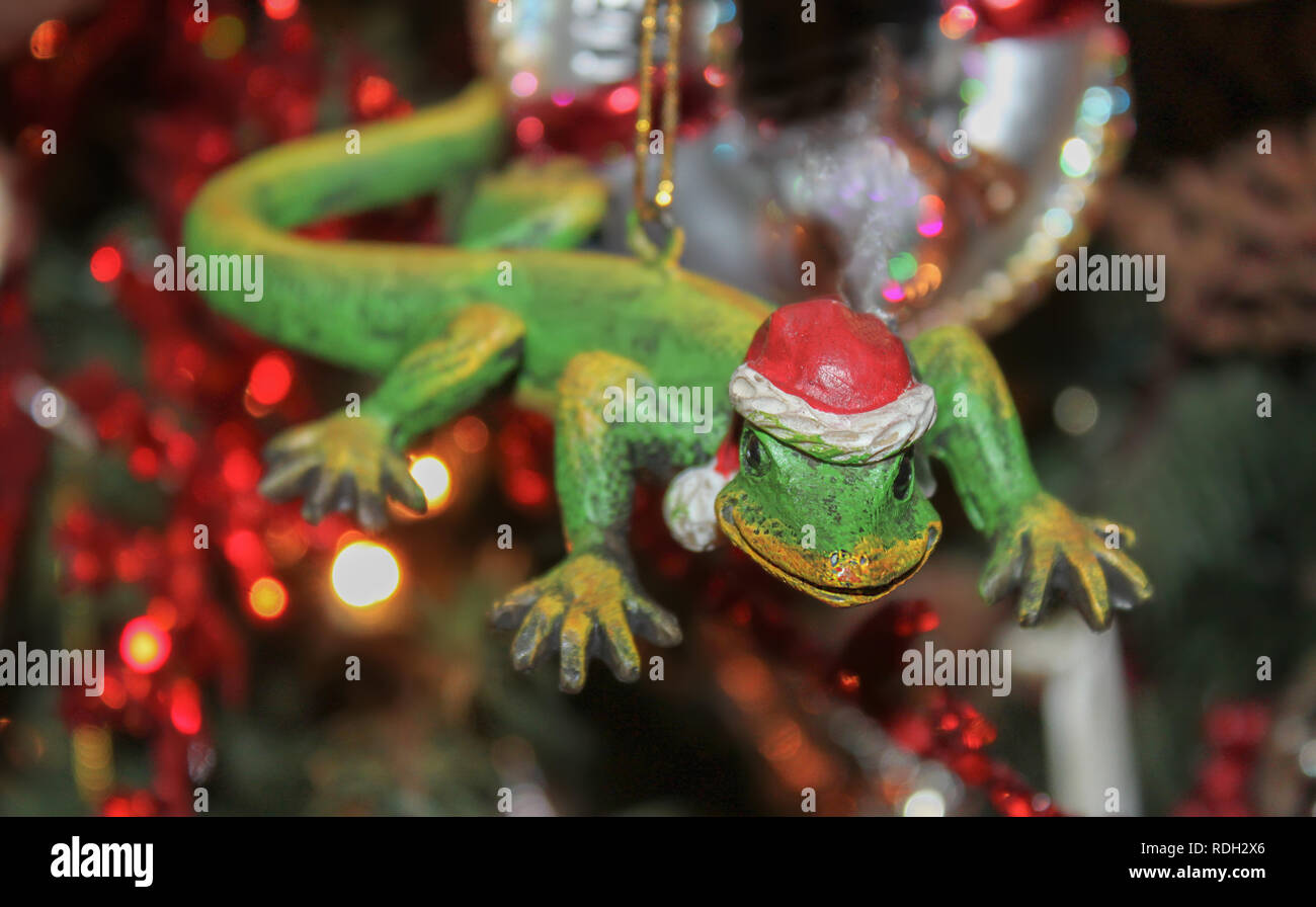 Il geco con Santa hat ornamento di Natale con albero sfocate con luci in background - messa a fuoco selettiva. Foto Stock