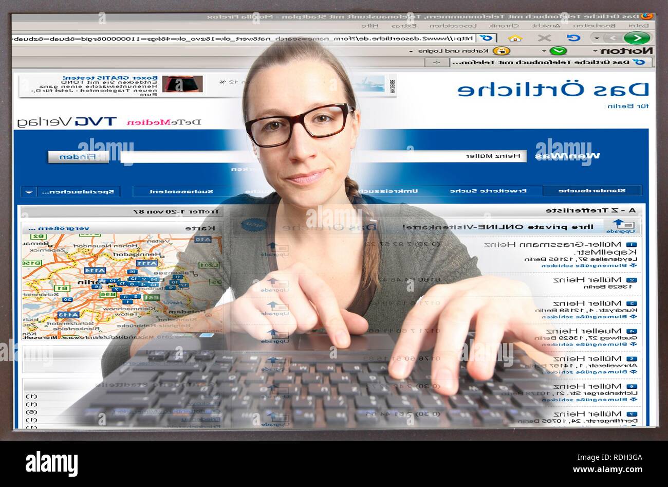 Donna navigare su internet su un computer, Das Oertliche rubrica nella pagina web, la ricerca di un numero di telefono, visualizzare dal monitor Foto Stock