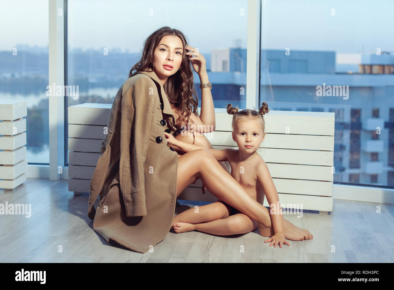 Ritratto di una bella famiglia presso la finestra. Mamma e figlia. Foto Stock