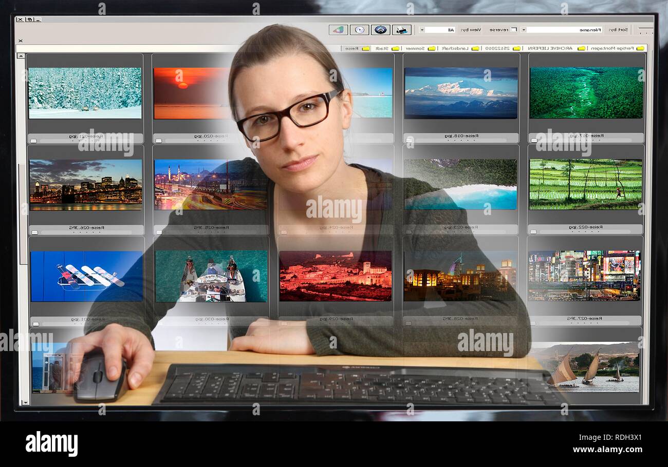Giovane donna seduta a un computer e visualizzare la sua collezione di foto con il software di editing fotografico, vista dall'interno del computer Foto Stock
