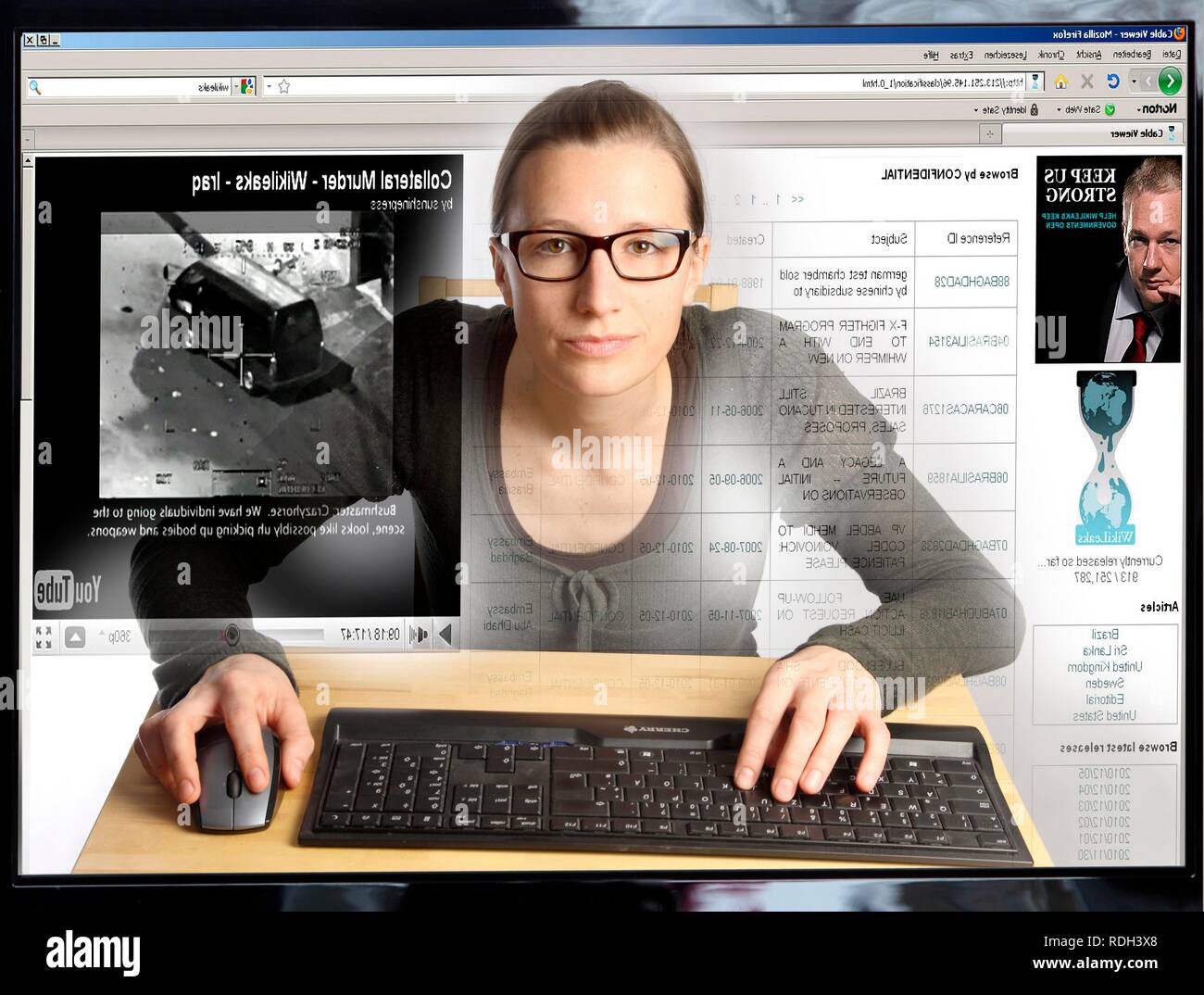 Giovane donna seduta a un computer per navigare in Internet, la visualizzazione di una pagina sul sito di WikiLeaks, vista dall'interno del computer Foto Stock