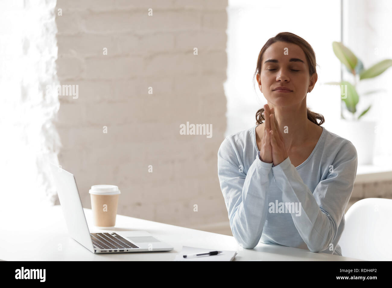 Imprenditrice mettere le mani insieme nella preghiera, meditando, rilassante Foto Stock