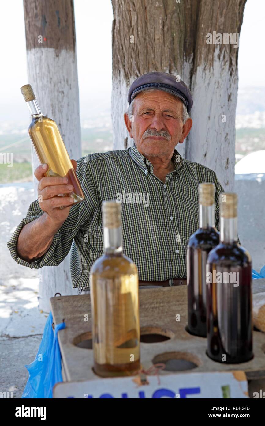 Uomo greco seeling vino casalingo, villaggio di montagna, Pyrgos, SANTORINI, CICLADI Mar Egeo, Grecia, Europa Foto Stock