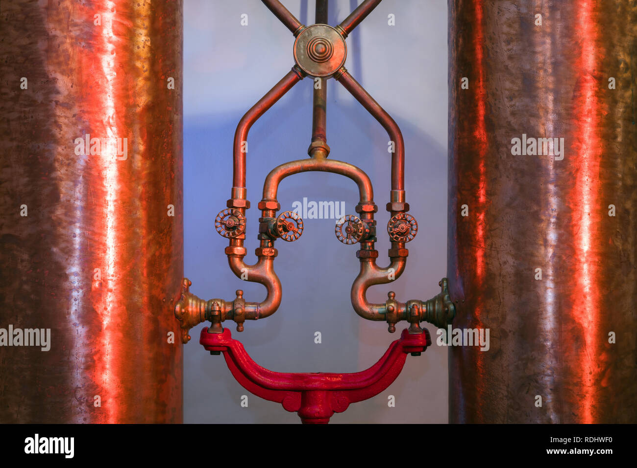 Rame industriale di barili per bevande forti. Shiny tubi metallici, maniglia a leva Foto Stock
