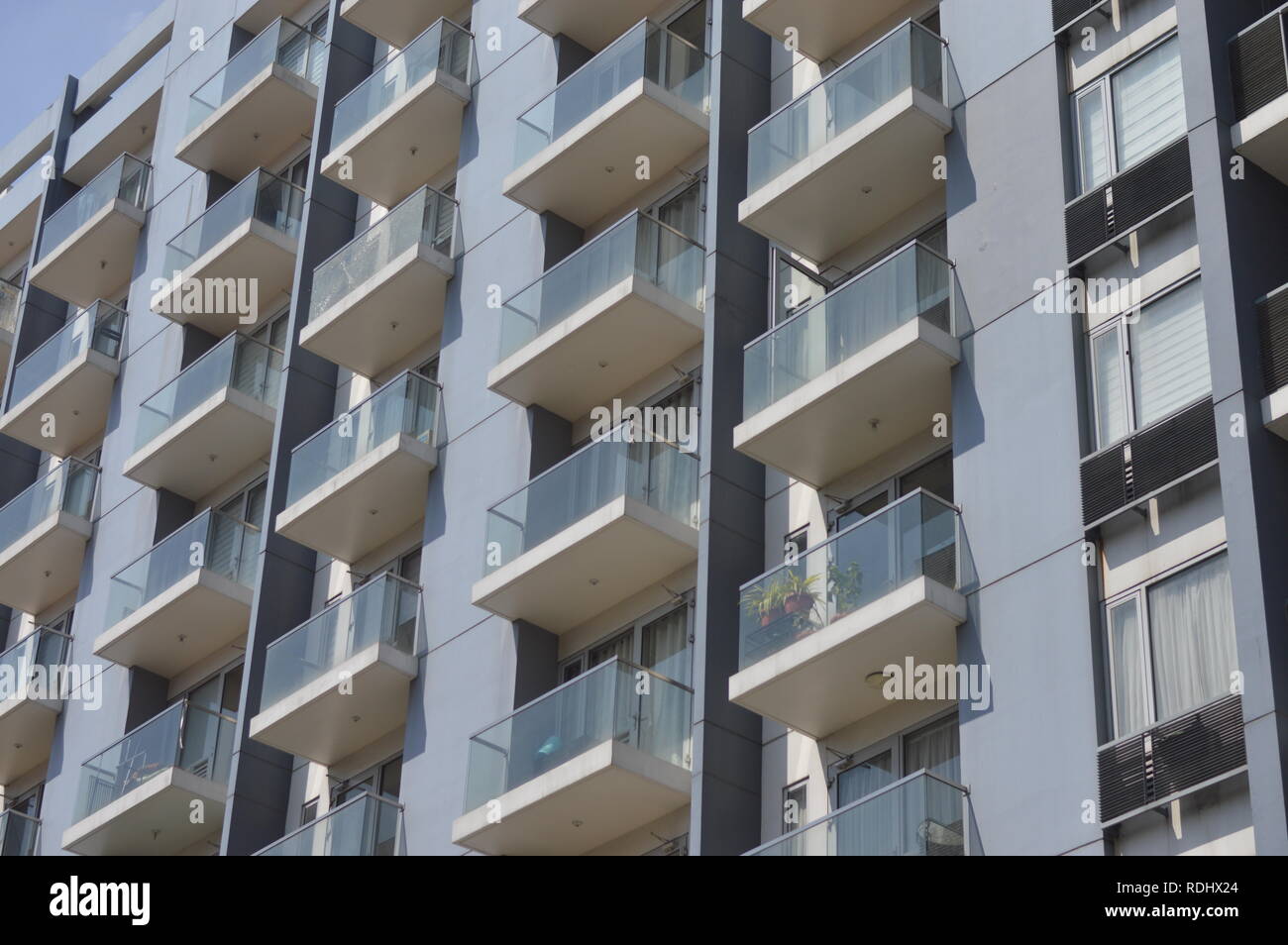 Il balcone di ogni camera di un condominio bianco durante un soleggiato dopo mezzogiorno di Pasay City, Filippine. Foto Stock