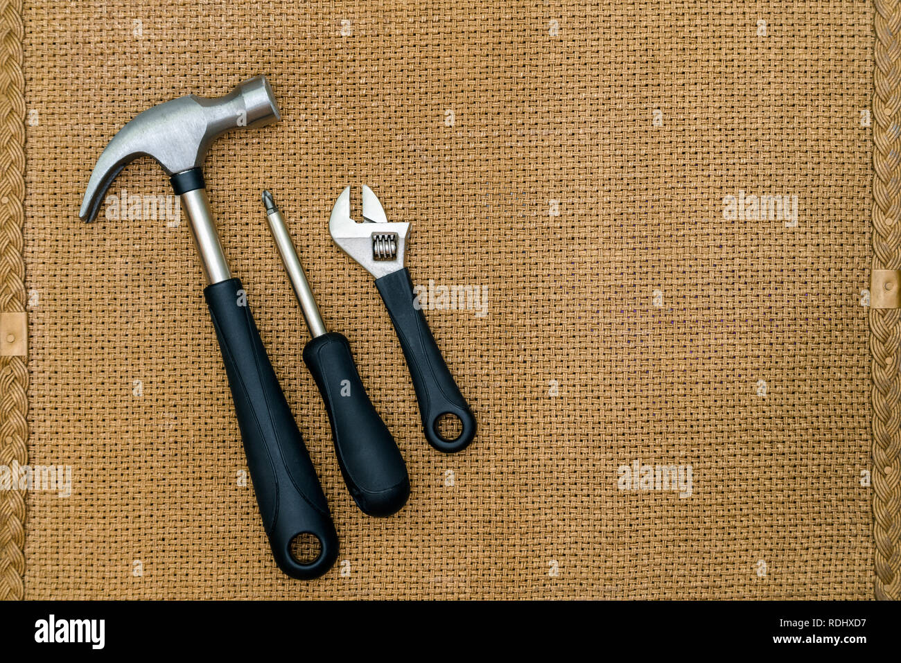 La riparazione degli strumenti ancora vita su sfondo marrone con spazio per digitare, pinze, cacciavite, martello Foto Stock