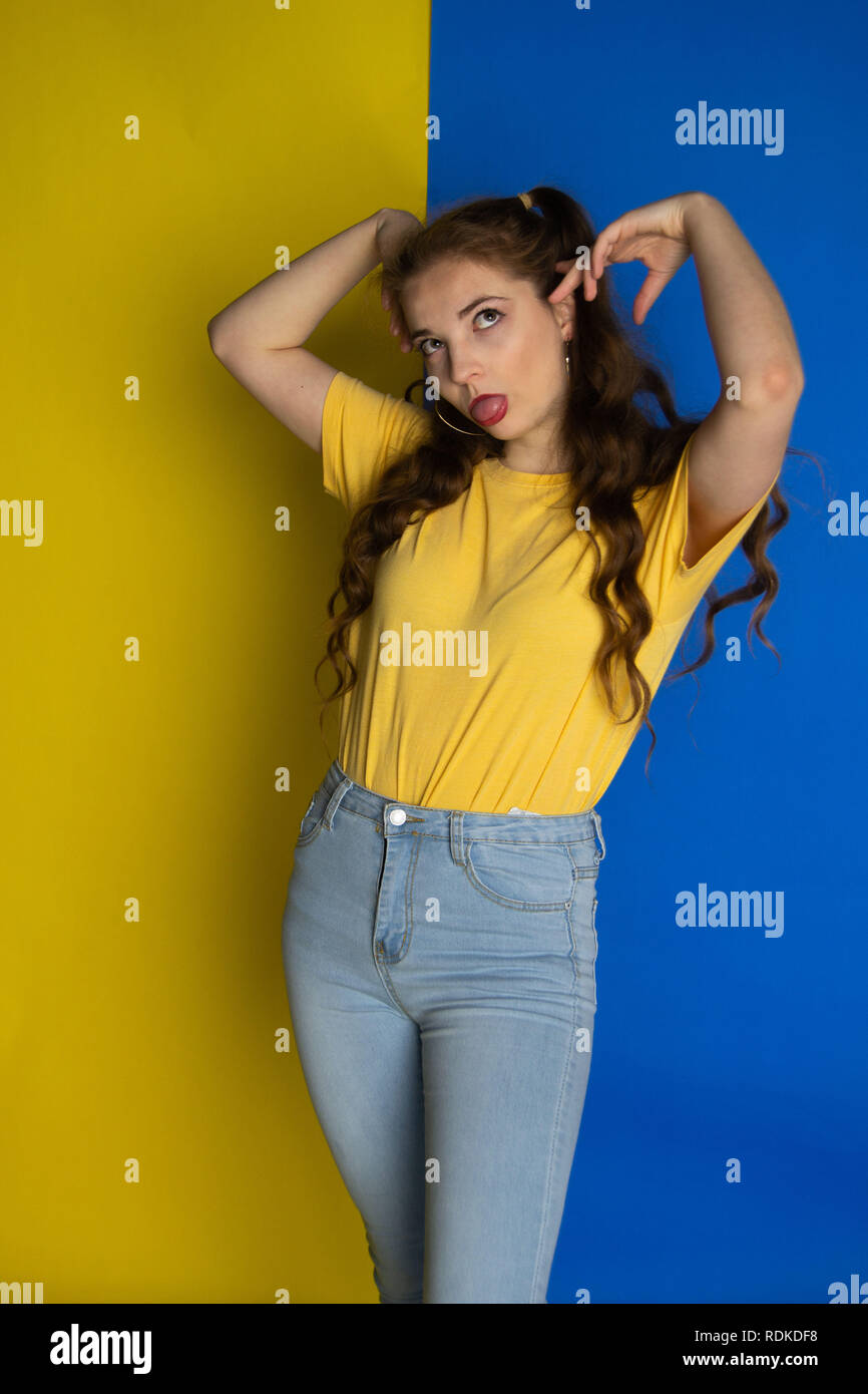 La modellazione femmina in giallo e blu abbigliamento per abbinare il suo background Foto Stock