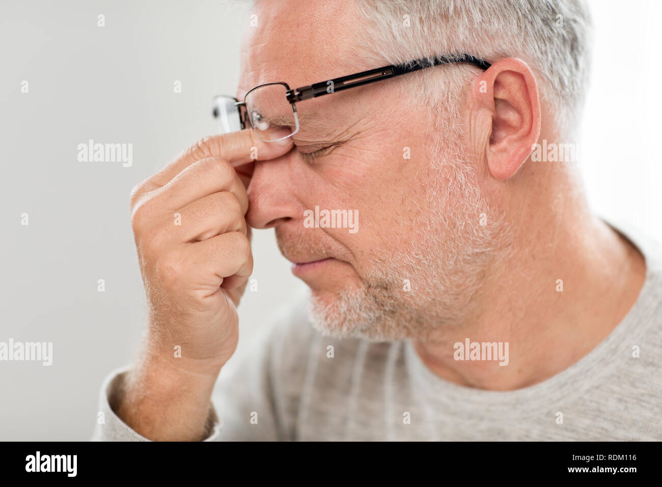 Senior uomo in bicchieri di massaggio ponte naso Foto Stock