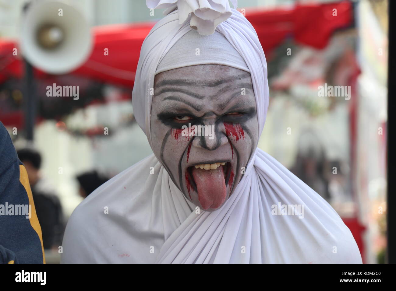 L'uomo gioca "pocong ruolo". Un inquietante Ghost in indonesiano crede. Foto Stock