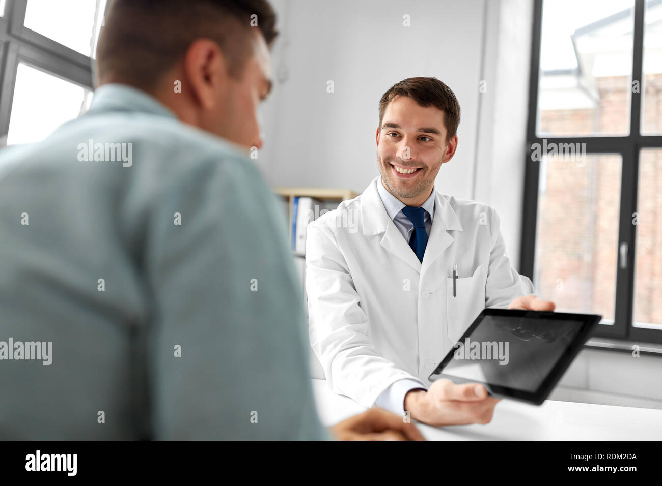 Medico con computer tablet e paziente presso la clinica Foto Stock