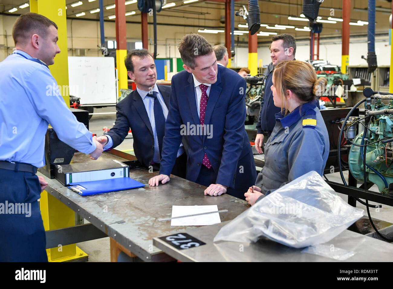 (Da sinistra a destra) Segretario gallese Alun Cairns e il Segretario della Difesa Gavin Williamson parlare al partecipante Gen Tech meccanico Rosie Owen durante una visita a MOD St Athan in Galles. Foto Stock