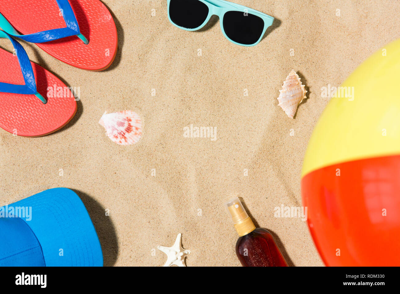 Tappo flip flop e sfumature e palla spiaggia sulla sabbia Foto Stock
