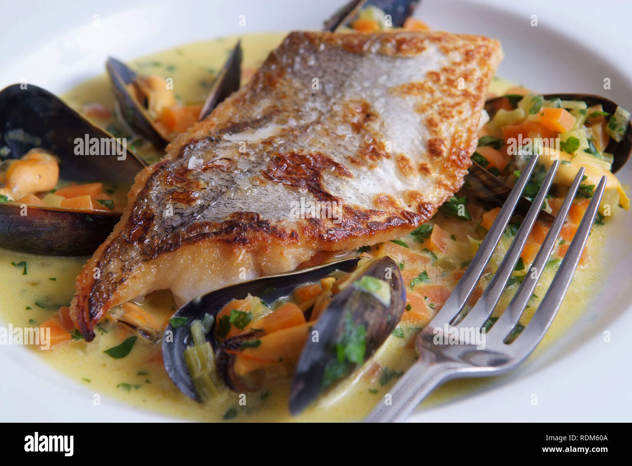 Filetto di nasello con cozze e zafferano Foto Stock