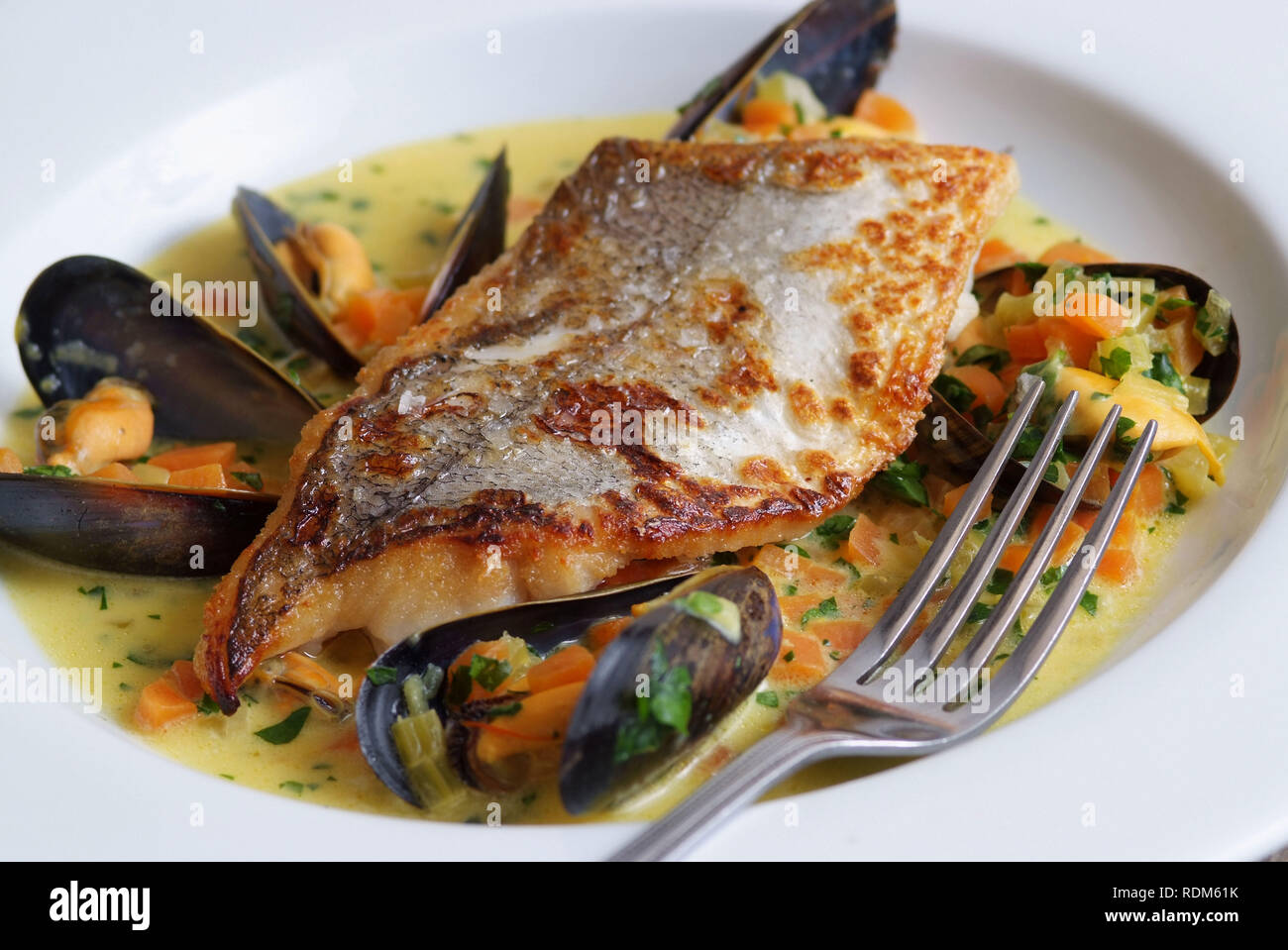 Filetto di nasello con cozze e zafferano Foto Stock