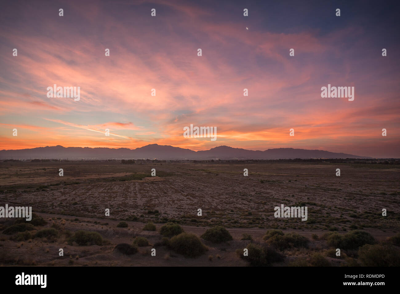 Un colorato tramonto sull'Alta Valle di El Paso Texas con una falce di luna e il Franklin montagne sullo sfondo Foto Stock