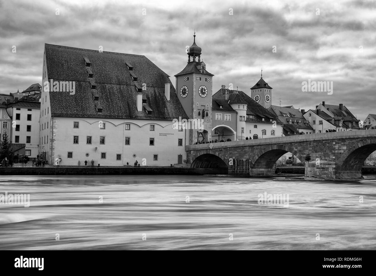 Pietra medievali arch ponte sopra il fiume Danubio con edifici storici e city gate, Regensburg, Germania. Foto Stock