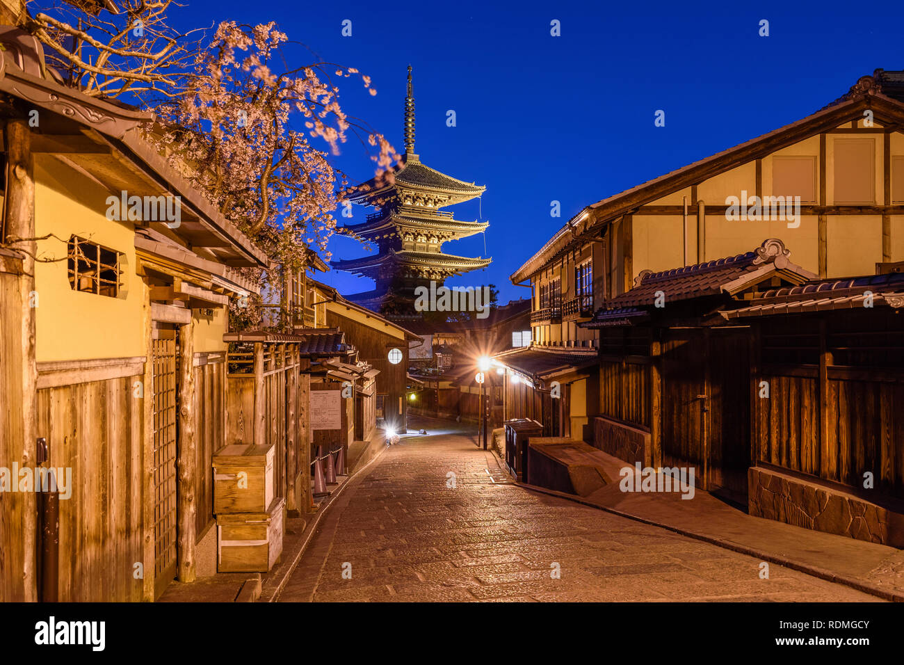Case tradizionali a rivestire una strada stretta con una pagoda in distanza, Higashiyama di notte, Kyoto, Giappone. Foto Stock
