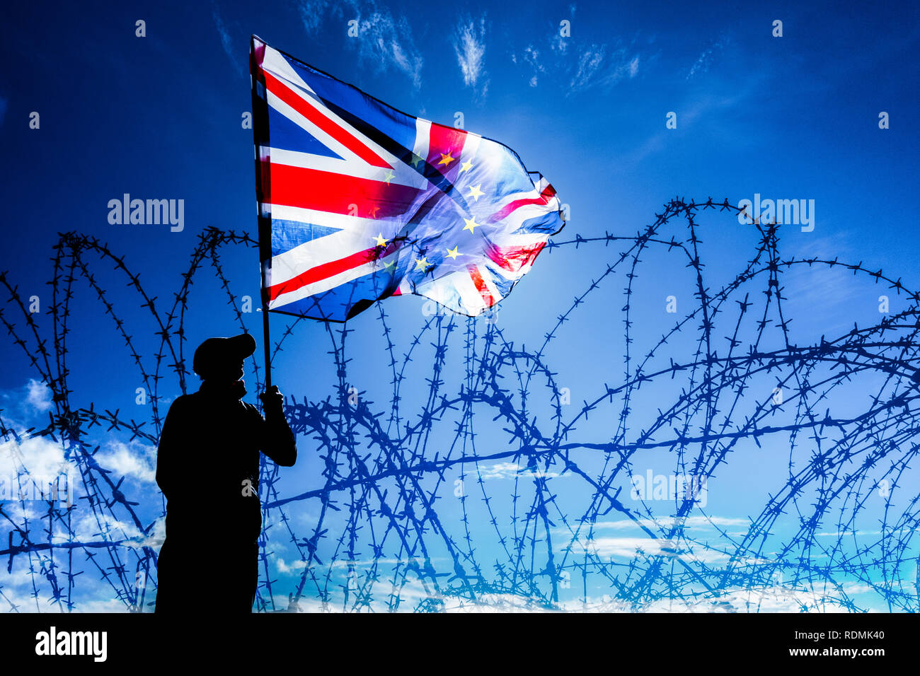 L'uomo sventolando Unione Jack/bandiera UE dietro al filo spinato recinzioni: Brexit, asilo, immigrazione e controllo delle frontiere...Concetto di immagine Foto Stock